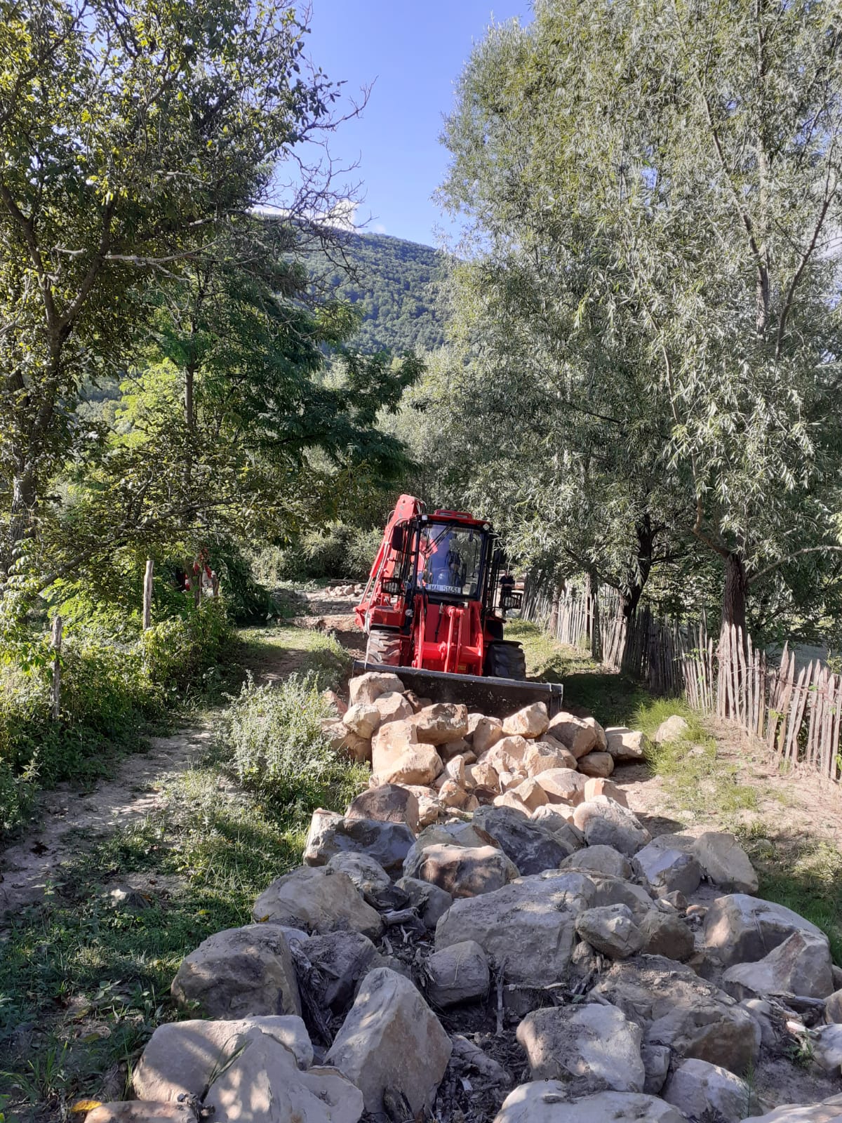 GALERIE FOTO Gospodării izolate rutier de două luni, din cauza unor bolovani uriași căzuți pe drum. Pompierii intervin cu utilaje