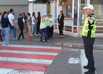 Traficul auto, dirijat la o trecere de pietoni de un grup de elevi